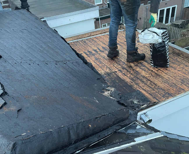 Daklekkagerepareren 1 Daklekkage reparatie, Daklekkage detectie man op dak reparatie van lekkage met zwarte laarzen